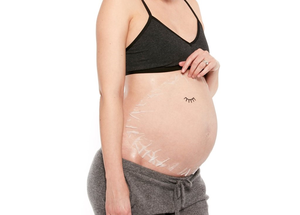 Barriga de uma mulher grávida com a Belly Mask, para uma gravidez sem estrias.